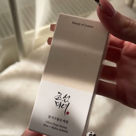 Boîte du sérum Beauty of Joseon Glow Deep Rice + Alpha-Arbutin présentée à la main.