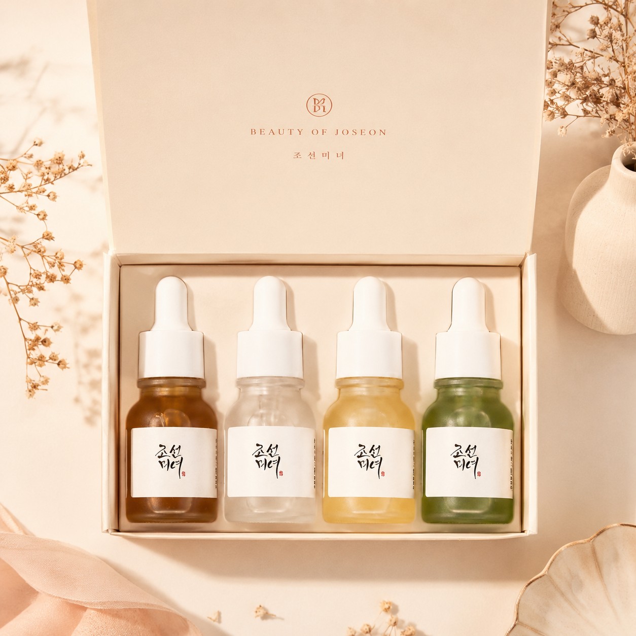 Les quatre mini-sérums Beauty of Joseon Glow, Glow Deep, Calming et Revive alignés sur un socle clair dans une ambiance terracotta.