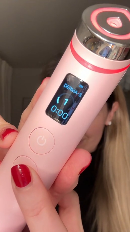 Gros plan du Medicube AGE-R Booster Pro Pink Edition allumé, avec écran de contrôle et anneau lumineux rose.