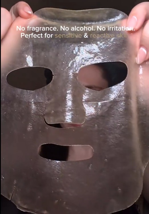 Masque hydrogel SKIN1004 Madagascar Centella tenu devant le visage pour montrer sa texture translucide.