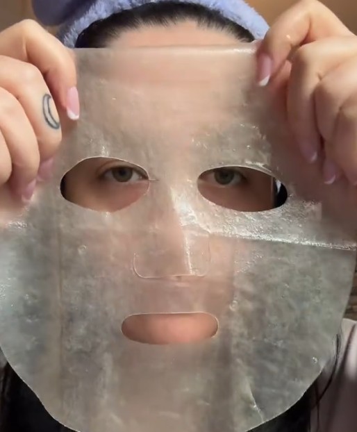 Masque hydrogel SKIN1004 Madagascar Centella tenu devant le visage pour montrer sa texture transparente et souple.