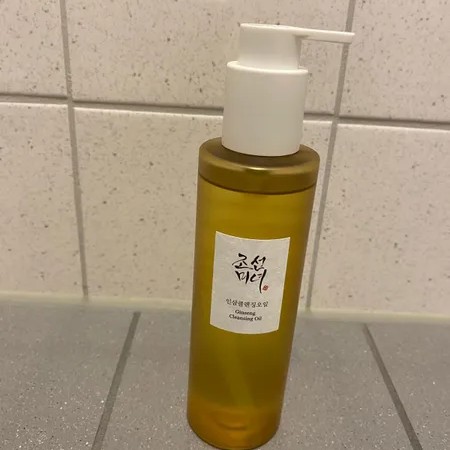 Beauty of Joseon Ginseng Cleansing Oil posé devant un mur carrelé de salle de bain.