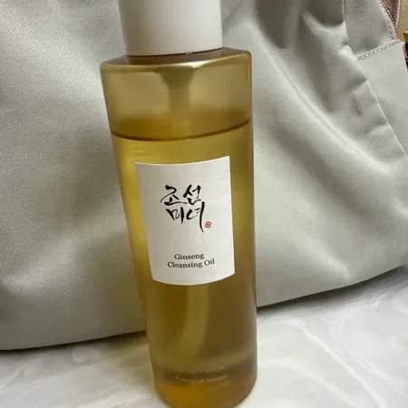 Beauty of Joseon Ginseng Cleansing Oil posé devant une trousse de toilette claire.