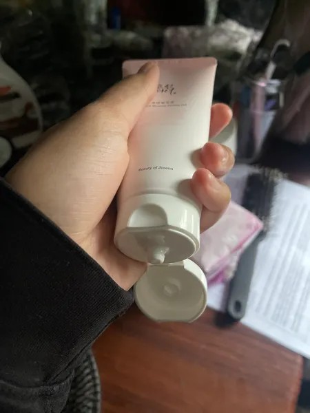 Beauty of Joseon Apricot Blossom Peeling Gel tenu en main avec le bouchon ouvert.