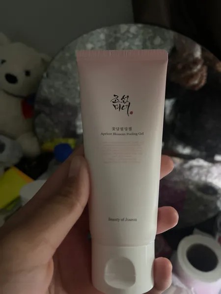 Beauty of Joseon Apricot Blossom Peeling Gel présenté dans une main devant un miroir.