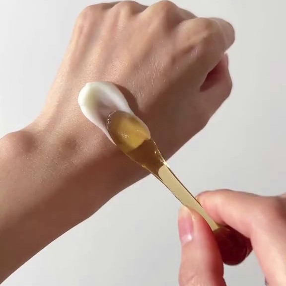 Texture de la Dr. Althea 345 Relief Cream étalée sur le dos de la main à l’aide d’une spatule.