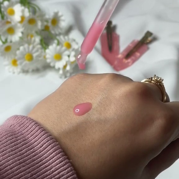 Texture rose du Medicube PDRN Pink Peptide Serum déposée à la pipette sur le dos de la main