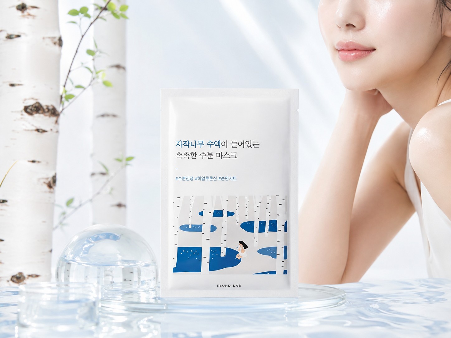 Masque ROUND LAB Silver Birch Juice présenté devant une femme à la peau lumineuse, dans un décor inspiré du bouleau.