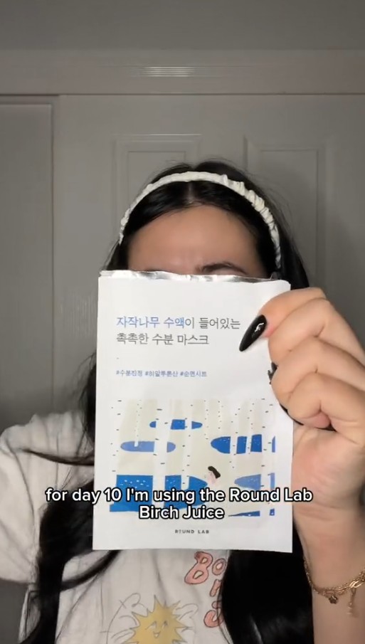 Femme tenant un sachet du masque ROUND LAB Silver Birch Juice devant son visage.