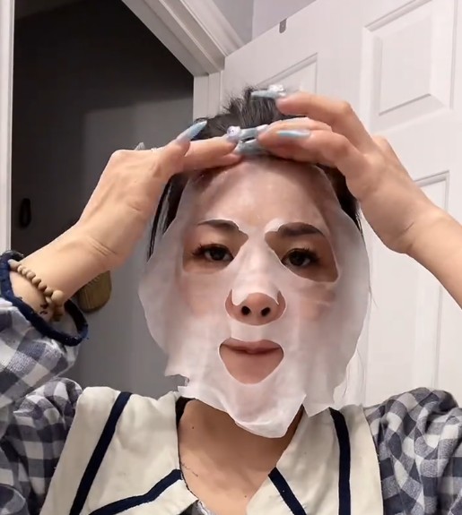 Femme ajustant le masque tissu ROUND LAB Silver Birch Juice sur le front et le contour du visage.