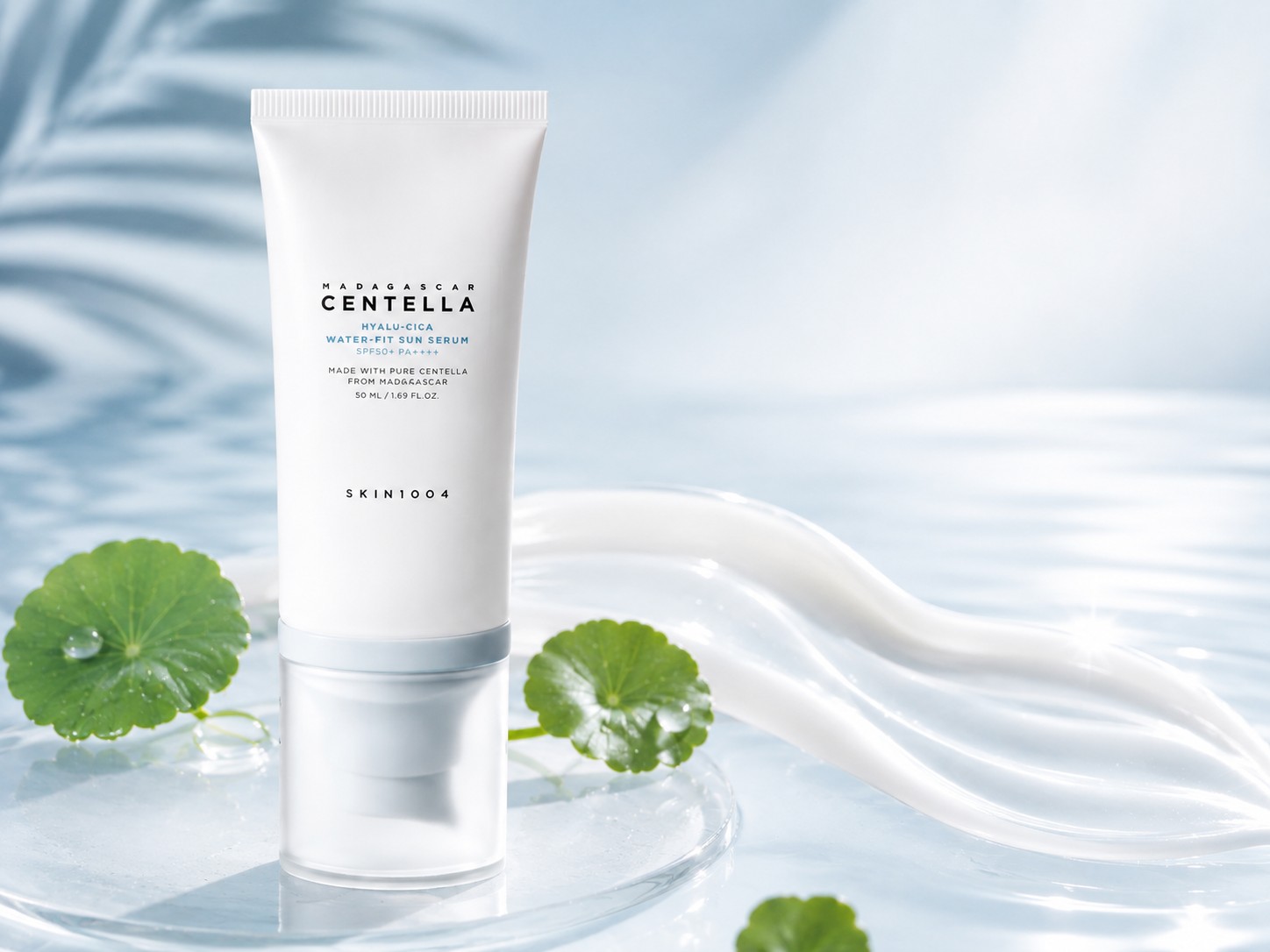 SKIN1004 Hyalu-Cica Water-Fit Sun Serum SPF50+ avec texture crème fluide et feuilles de Centella, illustrant un fini léger, lumineux et confortable.