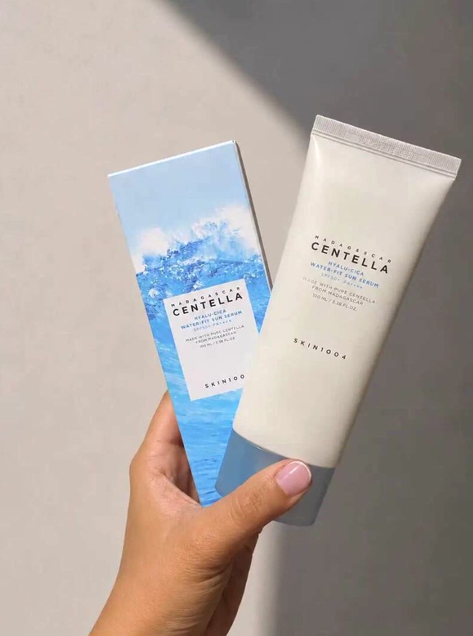 Main tenant ensemble la boîte et le tube du SKIN1004 Hyalu-Cica Water-Fit Sun Serum SPF50+.