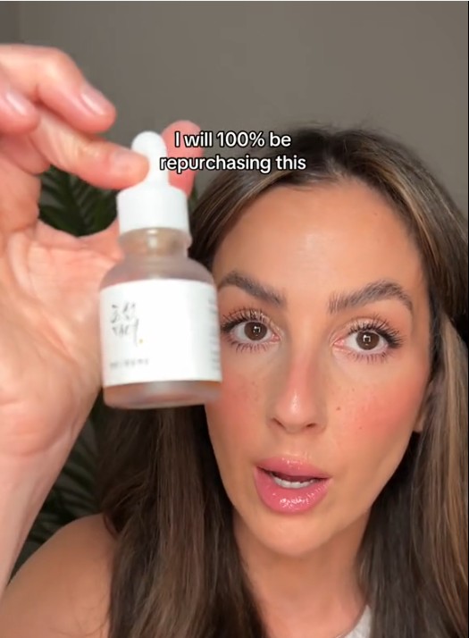 Utilisatrice présentant le flacon du Revive Serum Ginseng + Snail Mucin de Beauty of Joseon face caméra.