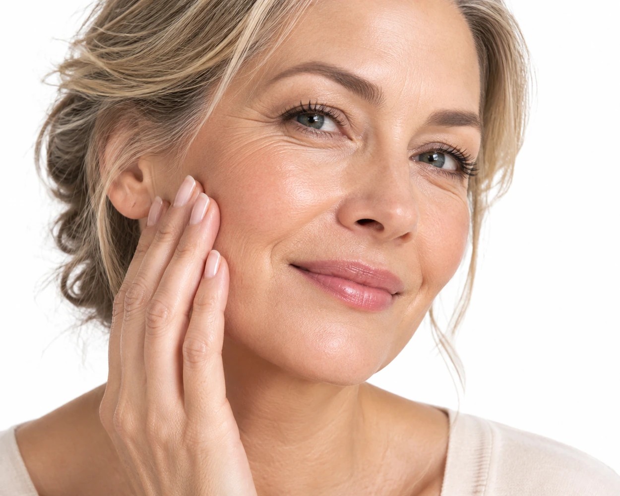Portrait lumineux d’une femme à la peau mature posant la main sur sa joue