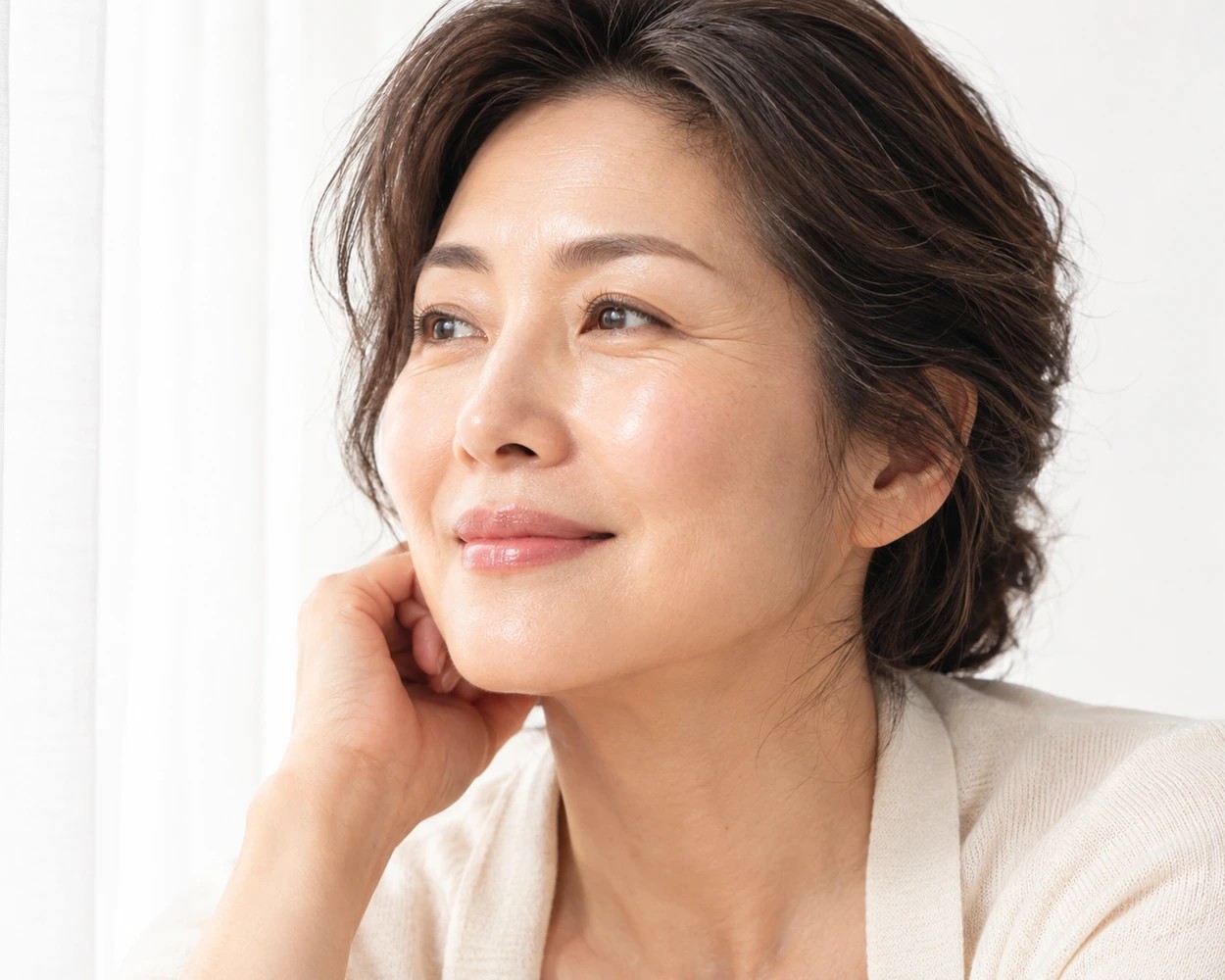 Femme à la peau mature et lumineuse souriant dans une pièce claire