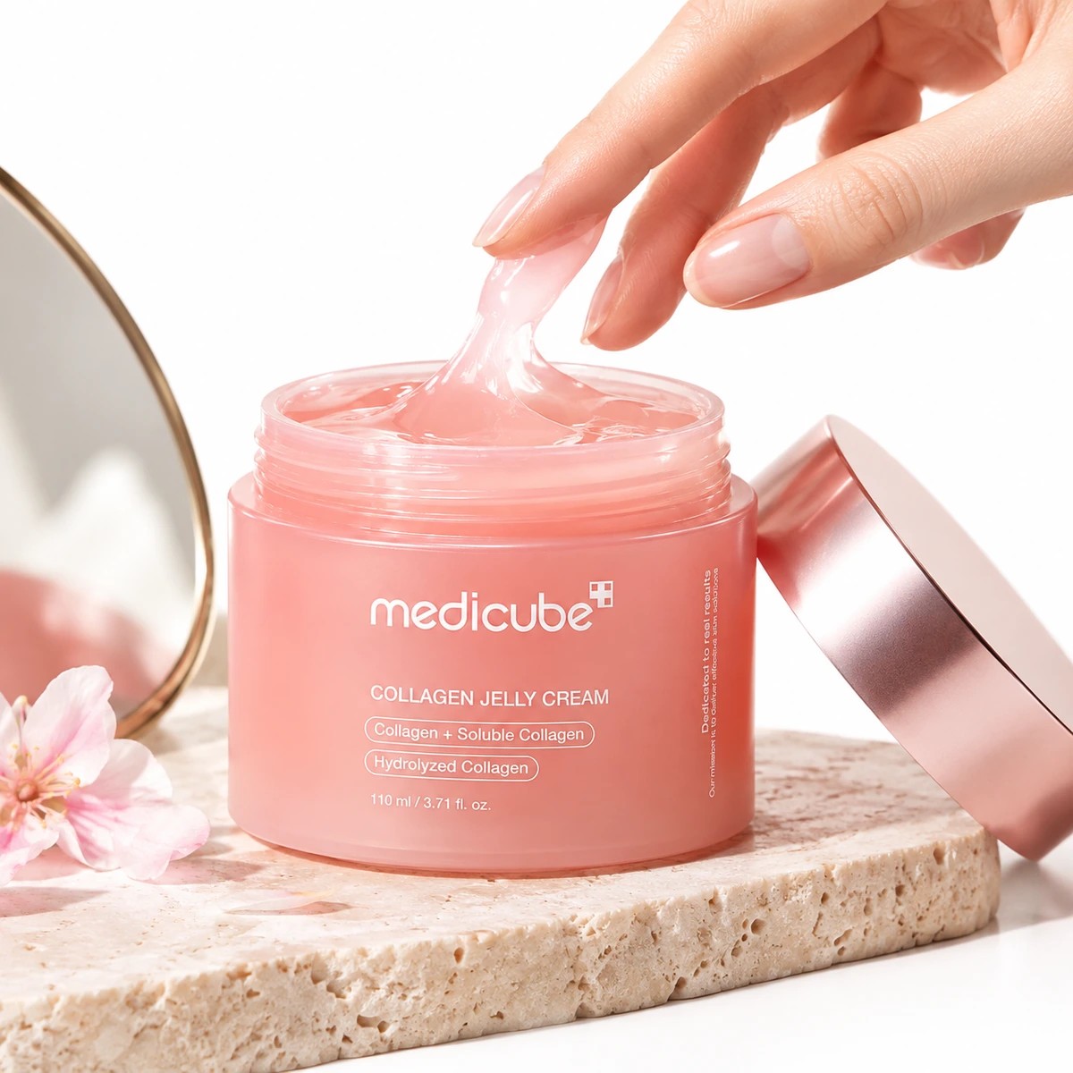 Pot ouvert de Medicube Collagen Jelly Cream avec sa gelée rose translucide prélevée du bout des doigts