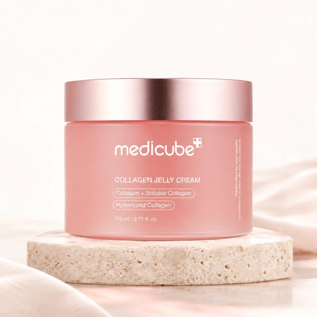 Pot rose fermé de la Medicube Collagen Jelly Cream posé sur une pierre claire dans un décor rose poudré