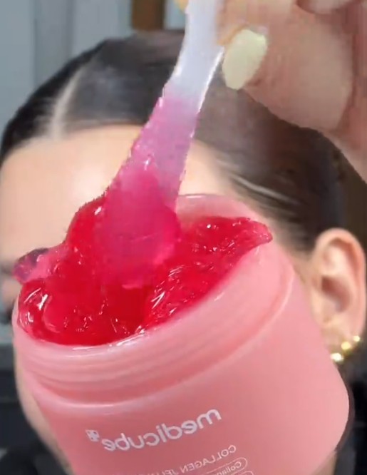 Spatule soulevant la texture gelée rose de la Medicube Collagen Jelly Cream au-dessus du pot ouvert