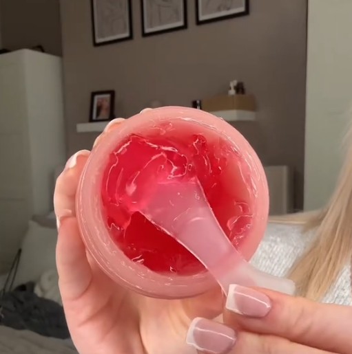 Pot ouvert de Medicube Collagen Jelly Cream vu de dessus avec sa gelée rose et une spatule