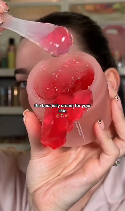 Utilisatrice présentant le pot ouvert et une spatule chargée de gelée rose Medicube Collagen Jelly Cream