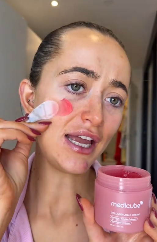 Utilisatrice appliquant la gelée rose Medicube Collagen Jelly Cream sur sa joue avec une spatule