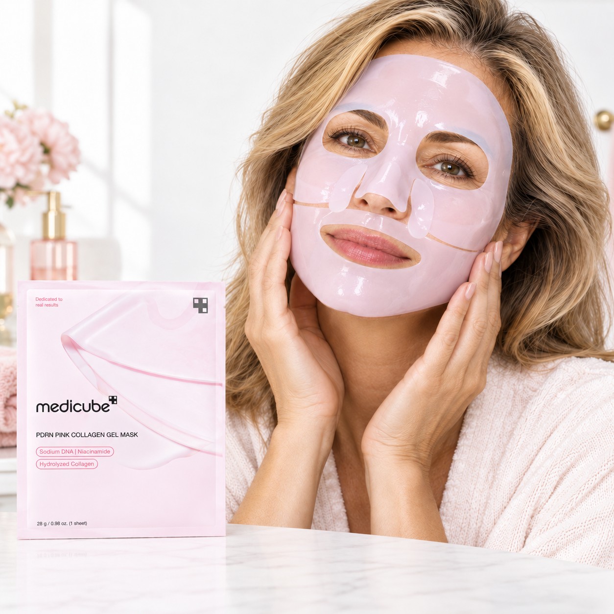 Femme portant le Medicube PDRN Pink Collagen Gel Mask rose, avec le sachet du produit à côté.