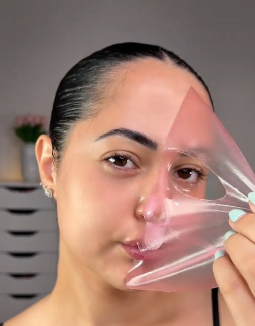Femme retirant du visage un masque hydrogel devenu presque transparent.