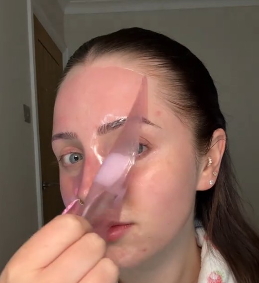 Femme retirant un masque hydrogel devenu transparent après la pose.