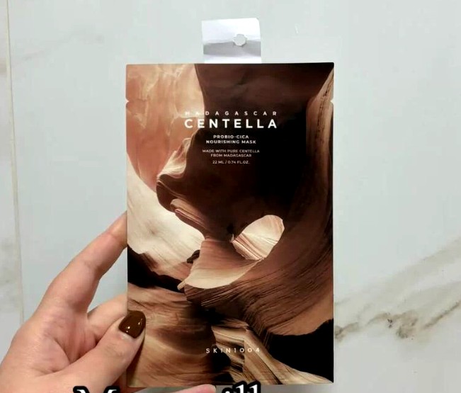 Main présentant un sachet du masque SKIN1004 Probio-Cica Nourishing Mask